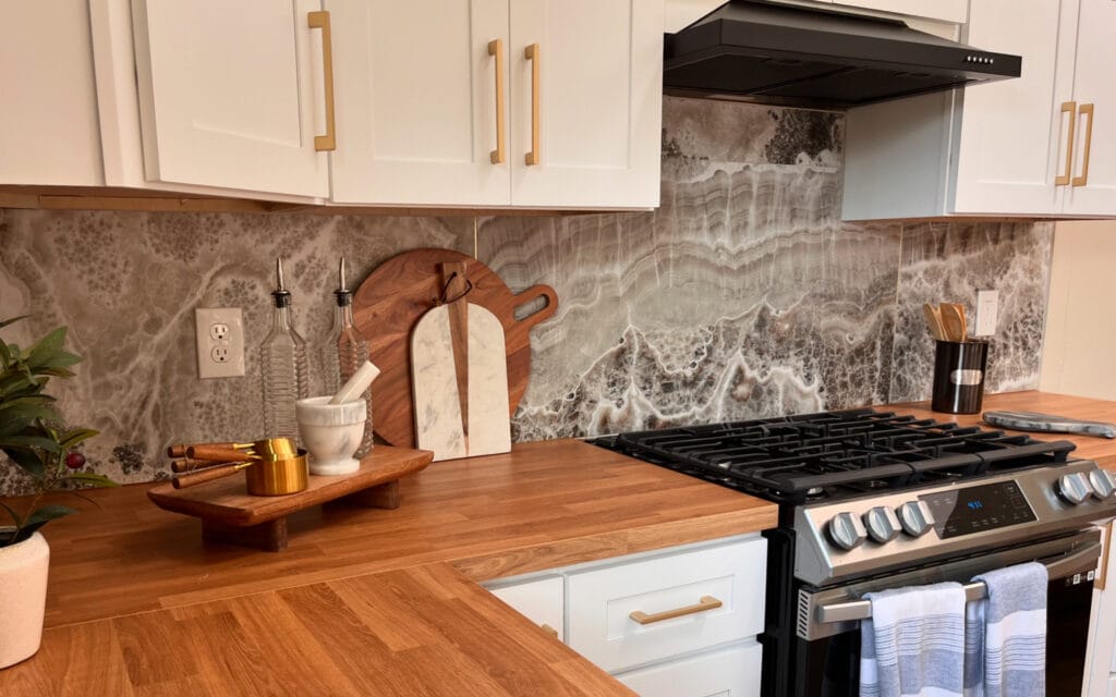 Cocina renovada con encimeras de madera y backsplash de mármol, proyecto de BMI Design & Decor en Texas.